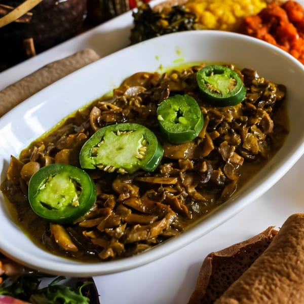 Desta Ethiopian Kitchen's mushroom tibs, a savory dish with sliced jalapeños, served with injera.